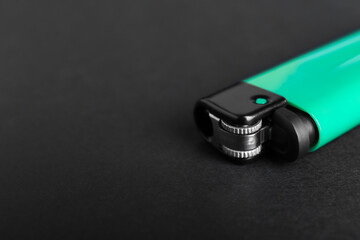 Stylish small pocket lighter on black background, closeup. Space for text