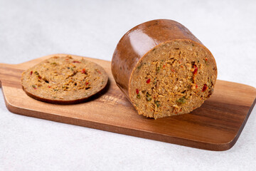 Mushroom based vegan sausage with vegetables and spices on wooden board, top view