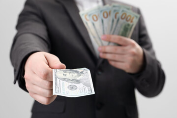 Man holding money on white background, closeup. Currency exchange