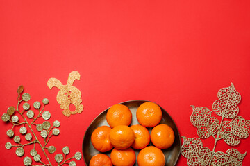 Chinese or lunar new year flat lay with plate of mandarins, paper rabbit as symbol of 2023 and...