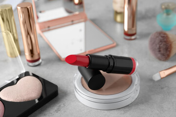 Beautiful pink lipstick and cosmetic products on light gray table