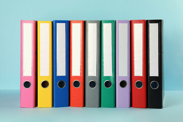 Many hardcover office folders on light blue background