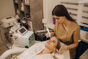 Close-up of woman getting facial hydro microdermabrasion peeling treatment. - obrazy, fototapety, plakaty
