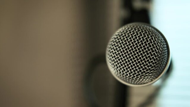 Close-up of a musician hand picking up a microphone for singing. put it on the mic stand. at home studio practice.