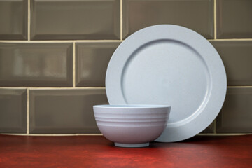 blue composite lightweight material camping dinner ware stacked in the kitchen on a red linoleum work top