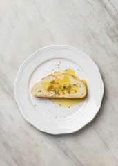 Slice of traditional bread whit olive oil EVO, top view on marble top