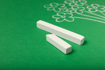 A bouquet of flowers drawn in chalk on a green blackboard. Concept Teacher's Day.