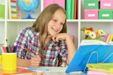 little girl studying at home at the table