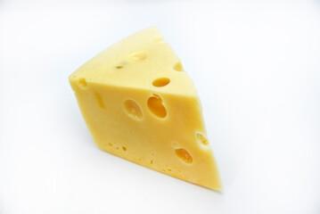 A large piece of cheese on a white background. A triangular piece of cheese with holes.