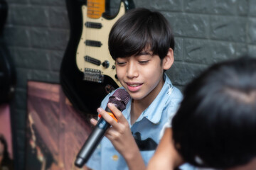 Fototapeta na wymiar Boy teenage singing with microphone on stage performance