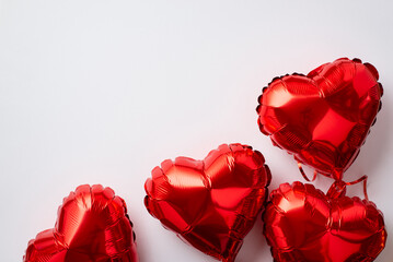 Valentine's Day concept. Top view photo of heart shaped red balloons on isolated white background...
