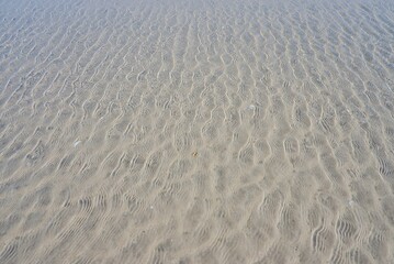  A texture of sea sand on the beach when the water raising tide  for backdrop background