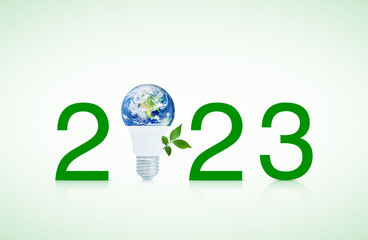 2023 text and earth globe inside led light bulb with fresh green tree leaves, Happy new year 2023 ecology and saving energy concept, Elements of this image furnished by NASA