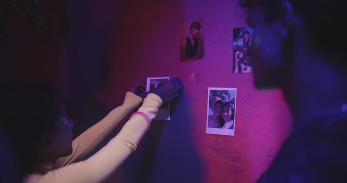 Friends pinning photos on a wall 