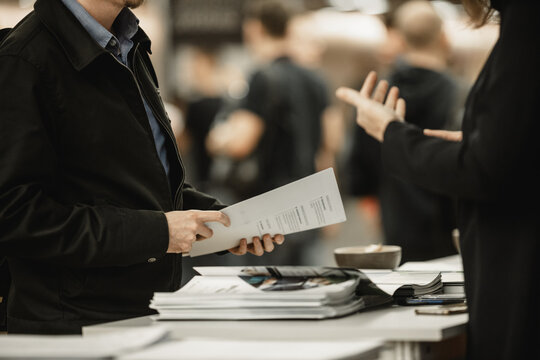 Business People Exchanging Business Promotional Materials And Brochure On Business Meeting On Trade-show. Business Discussion Talking Deal Concept