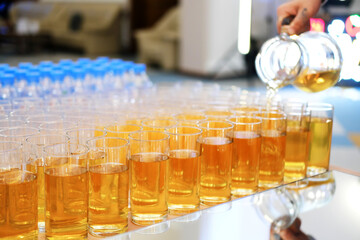 The waiter pours apple juice into a glass on the buffet line