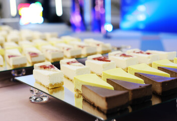 Pieces of cheesecakes on a mirrored tray on the buffet table