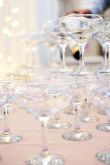 Pyramid of empty champagne glasses against golden bokeh background