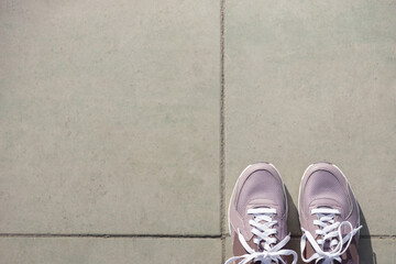 pink new sneakers stand on gray paving stones. Place for text. View from above