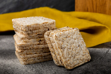 puffed rice bread on black texture background. Healthy crunchy snack. Whole grain crispy bread. Healthy food. Diet. Copy space. Place for text.