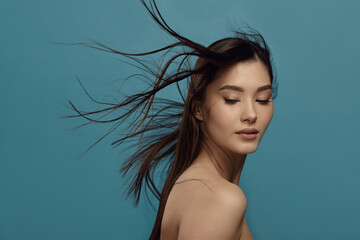 Beautiful female model with dark hair blowing in wind.