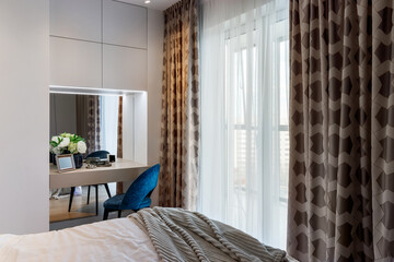 Stylish bedroom interior with an elegant toilet table and access to the balcony