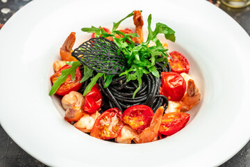 black pasta with shrimp and cherry tomatoes. Delicious balanced food concept