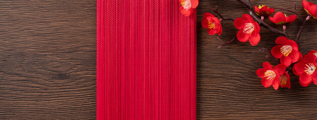 Chinese lunar new year background design concept with plum flower, red envelope and festive decorations.