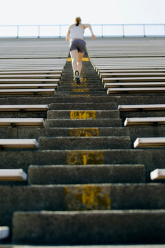 A runner sprints up the stairs of a stadium.