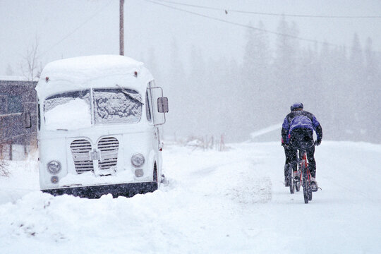 Rear view of a biker riding in snow, Colorado, USA.