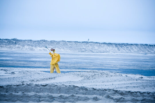 A scare crow on a tailings pond tries to keep the birds from landing on the toxic sands.