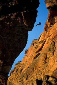 A climber rappels down Monkey Face at Smith Rock State Park, Oregon.