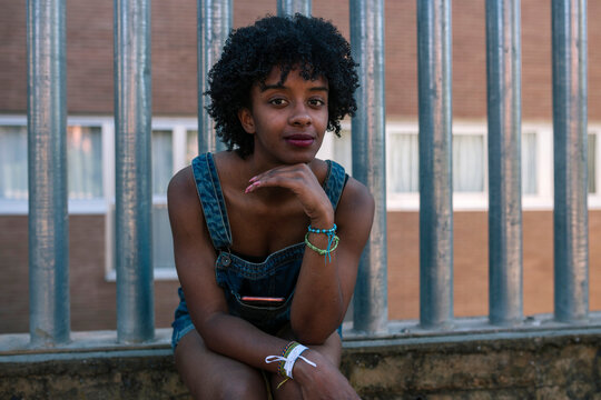 Black Young Woman With Afro Hair Sitting Pensive