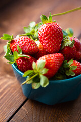 Fresh strawberries in a bowl on a wooden table