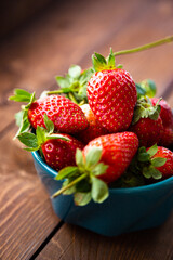 Fresh strawberries in a bowl on a wooden table