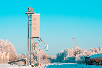 Obraz premium Grain elevator next to railroad during winter season