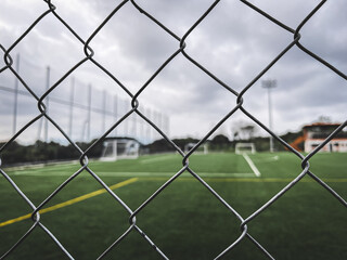 A soccer field view, focusing at the fence