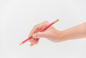 赤い色鉛筆を持つ女性の手