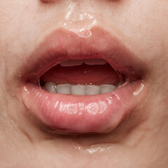Fototapeta premium Breath. Closeup of beautiful sensual woman's lips covered with honey, transparent gel. Beauty, fashion, style concept. Emotions and feelings