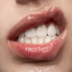 Anger. Close-up expressive female mouth with white straight teeth grimacing. Sensual woman's lips covered gel. Beauty, makeup, sensuality concept