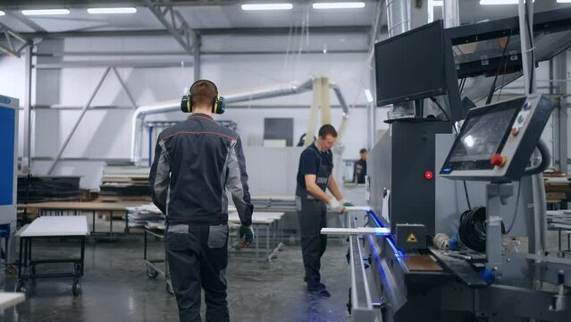 production of furniture and building materials in modern factory, workers work with modern equipment