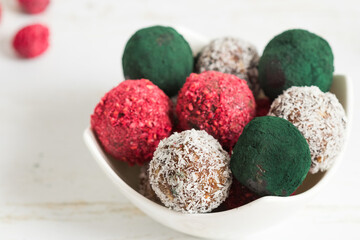 Healthy energy balls in italian and hungarian colors, red, white and green, served in a white plate.