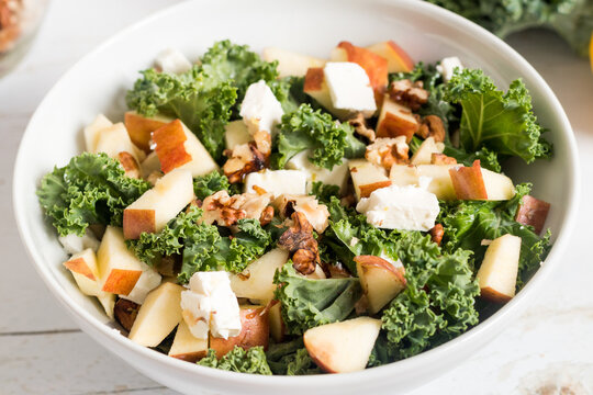 Crunchy autumn salad with kale, fruits and nuts, top view
