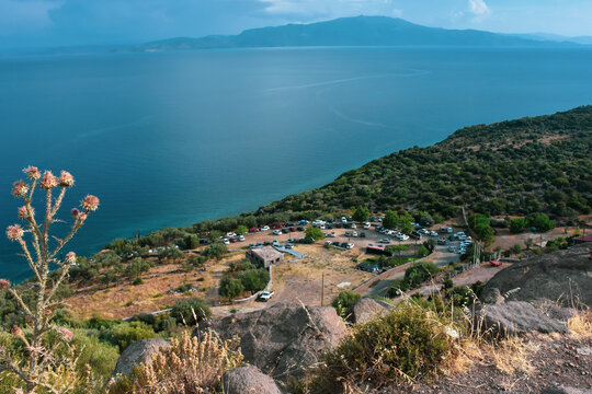 Visitors to the ancient city of Assos park their vehicles on the slope of the mountain and enjoy the magnificent view of Edremit bay in Aegean Turkey
