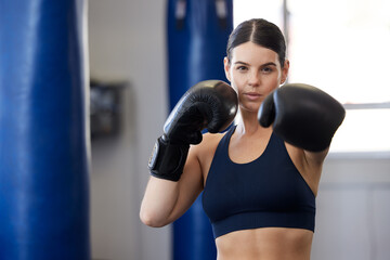 Fototapeta premium Fitness, kickboxing and portrait of woman athlete doing a cardio workout while training for a match. Sports, exercise and female boxer getting ready for a fight in sport, wellness and health gym.