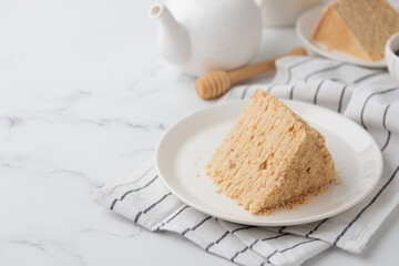 Piece Of Layered Homemade Honey Cake on the white table