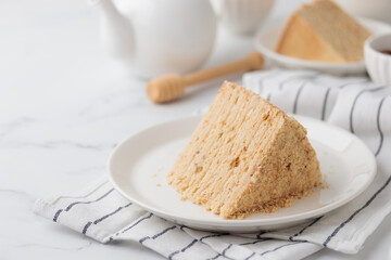 Piece Of Layered Homemade Honey Cake on the white table