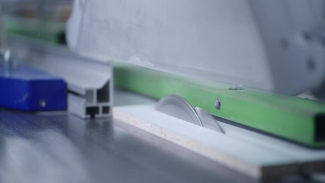 automated sawing machinery in furniture factory, closeup view, cutting wooden details safe