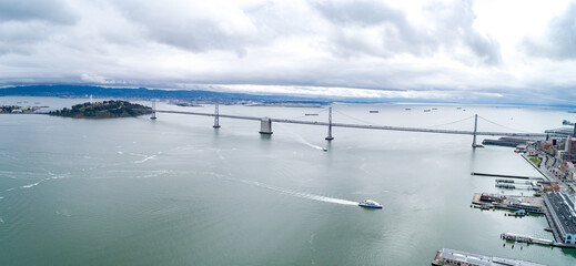 San Francisco - Oakland Bay Bridge with Cloudy Sky in Background. San Francisco, California. Drone