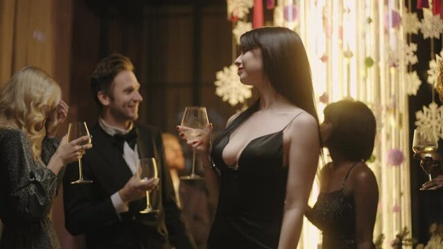beautiful woman is star of party, lady holding champagne glass and dancing in center of dance floor